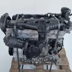 Silnik Volvo T6, gotowy do montażu. Potężna jednostka napędowa z widocznymi elementami osprzętu, umieszczona na drewnianej palecie.