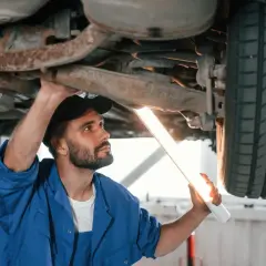Mechanik bada podwozie auta lampą. Czy można zrobić przegląd bez dowodu rejestracyjnego? Sprawdźmy!