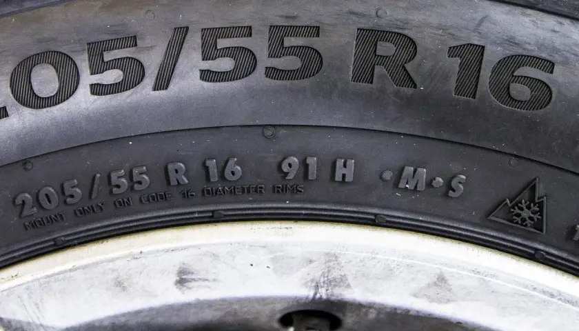 Opona z oznaczeniem 205/55 R16, indeks nośności opony 91H, symbol M+S i górski z płatkiem śniegu.