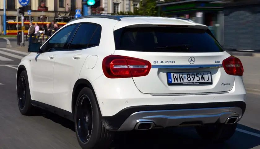 Biały Mercedes GLA 200 na polskich tablicach rejestracyjnych jedzie ulicą miasta.