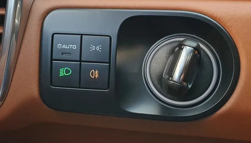 Przycisk z pomarańczową ikoną mgły to jak włączyć światła przeciwmgielne. Obok przyciski świateł i AUTO.