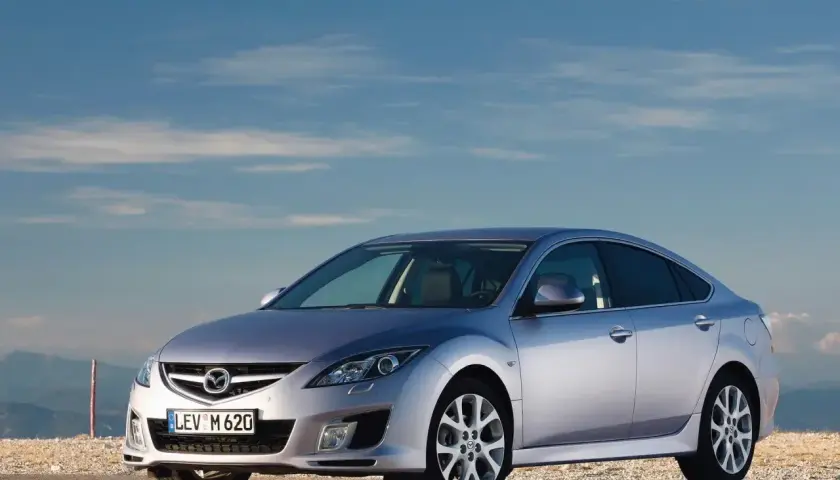 Srebrna Mazda 6 2.0 benzyna na tle błękitnego nieba i gór.