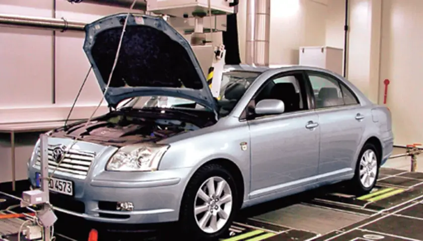 Srebrna Toyota Avensis 2.0 D4D z otwartą maską stoi na stanowisku diagnostycznym.