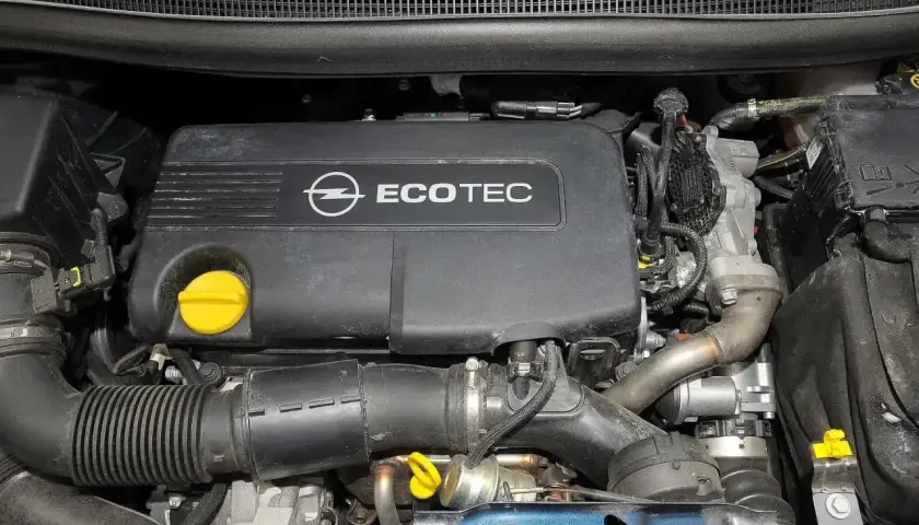 Silnik Ecotec w Opel Meriva 1.7 CDTI. Widoczny czarny plastikowy dekiel z logo Opla i napisem Ecotec, żółty korek oleju, przewody i elementy układu dolotowego.