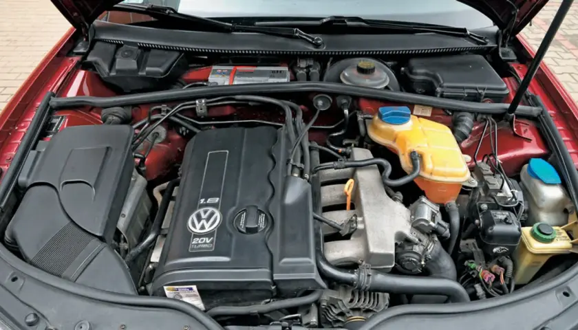 Silnik 1.8t Volkswagena z widocznym logo i oznaczeniem 20V TURBO. Widać elementy układu chłodzenia i dolot powietrza.