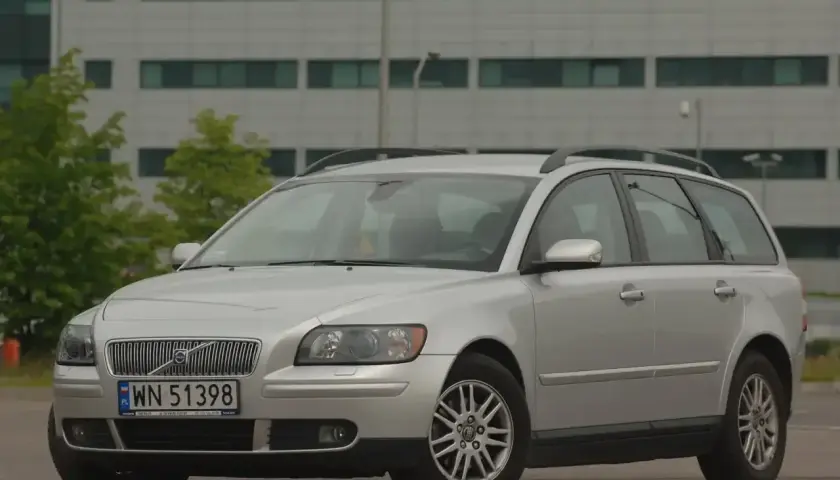 Srebrne Volvo V50 1.6 diesel na tle nowoczesnego budynku.