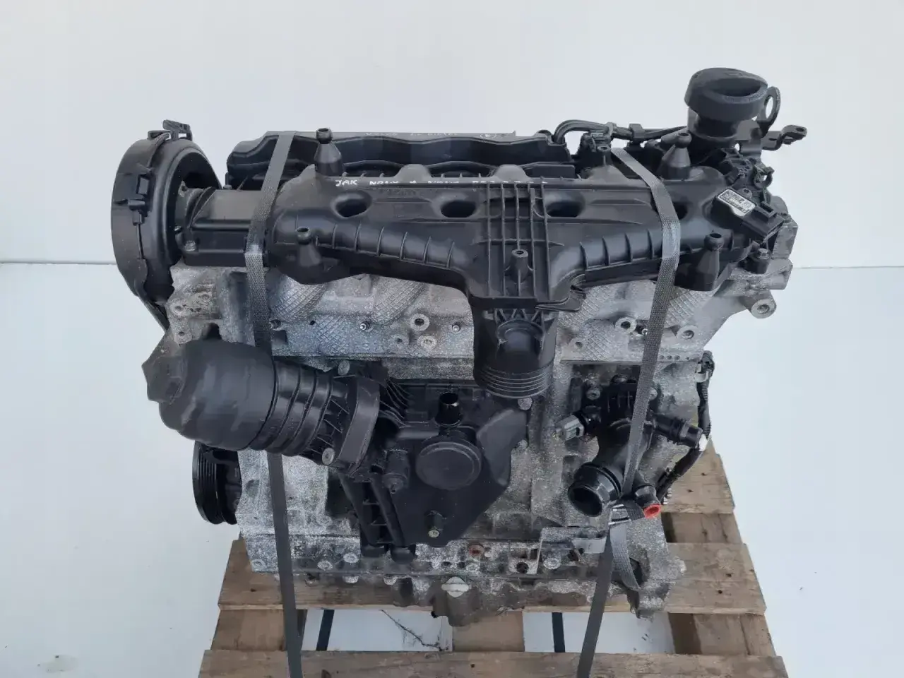 Silnik Volvo T6, gotowy do montażu. Potężna jednostka napędowa z widocznymi elementami osprzętu, umieszczona na drewnianej palecie.