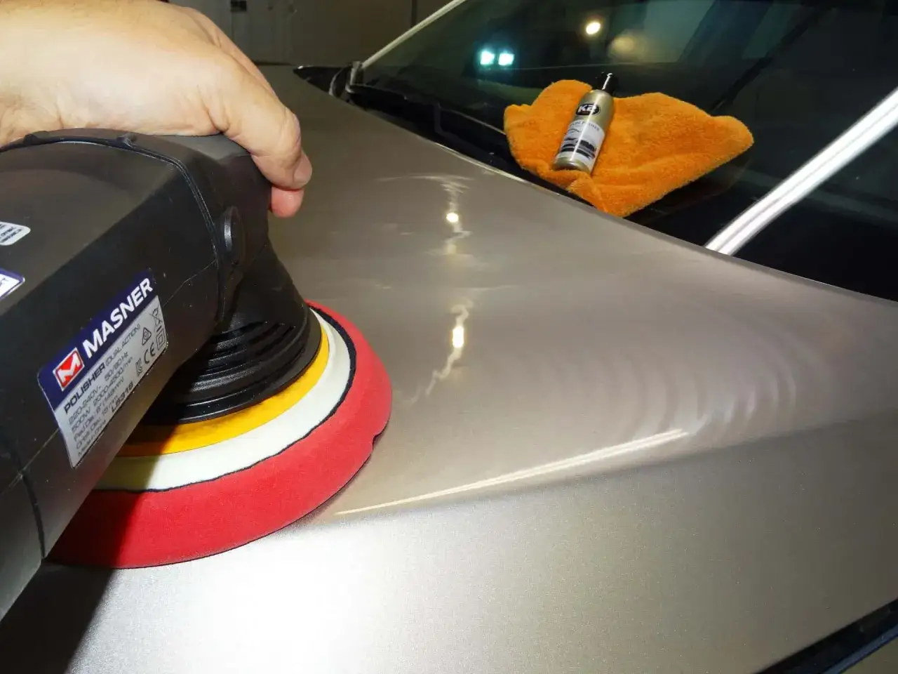 Polerowanie lakieru maszyną. Przygotowanie do nałożenia ceramiki na auto. Koszt takiej usługi może się różnić.