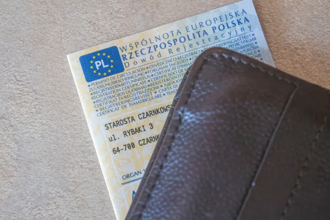 Dowód rejestracyjny pojazdu i brązowy portfel. Czy można zrobić przegląd bez dowodu rejestracyjnego? Dokument zawiera dane pojazdu i adres urzędu.